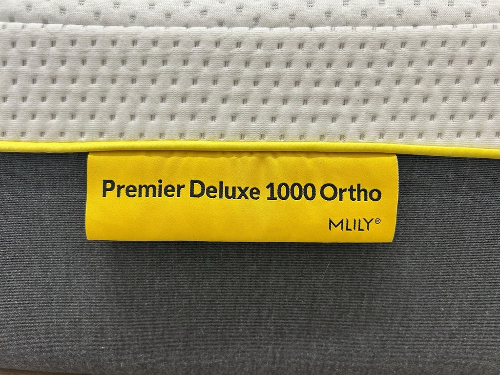 Mlily Premier 1000 Deluxe 5FT Kingsize firm orthopaedic mattress, showing a plush, neatly made bed with a white and grey bedspread.
