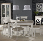 Bentley Designs washed oak extending dining table with four grey leather chairs, showcasing a modern table and chair set.
