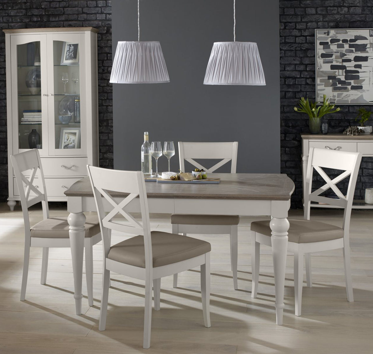 Bentley Designs washed oak extending dining table with four grey leather chairs, showcasing a modern table and chair set.