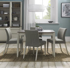 Bentley Designs washed oak dining table set with four grey fabric chairs, modern table and chair set for dining room.