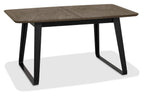 Weathered oak top extending dining table with black metal base by Bentley Designs, showing the table's surface and sturdy legs.