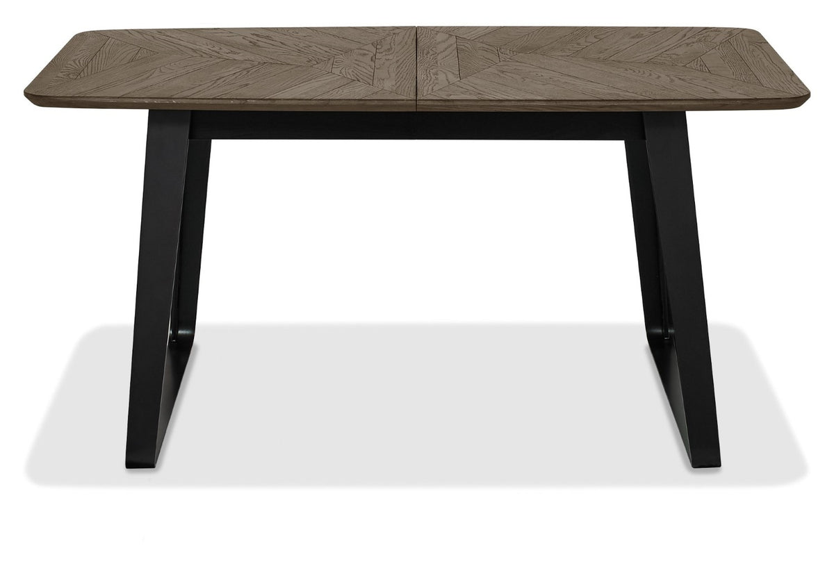 Weathered oak top extending dining table with black metal base by Bentley Designs, showcasing its sturdy construction and modern style.
