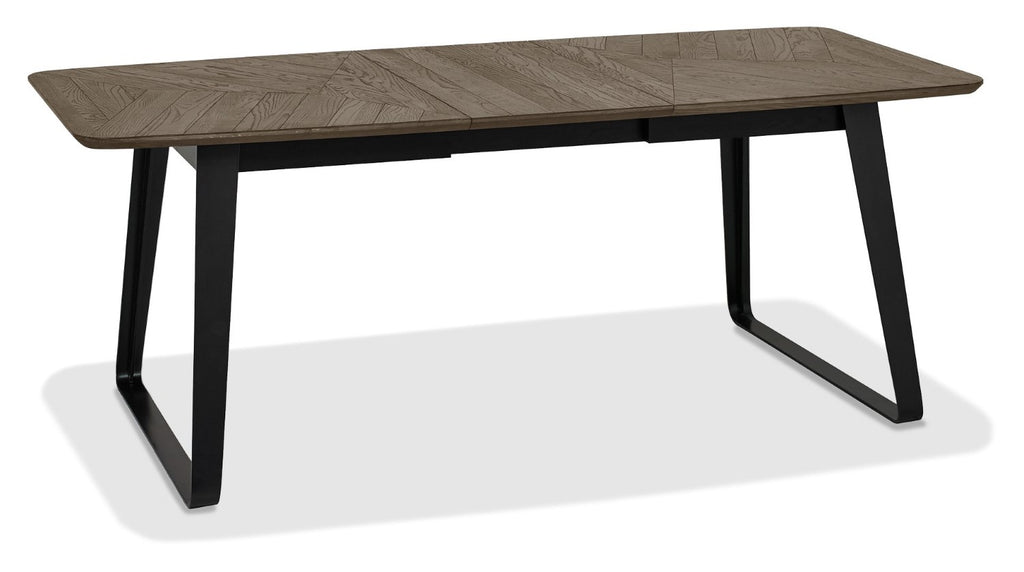 Weathered oak top extending dining table with black metal base by Bentley Designs, showcasing a modern, sturdy design.