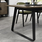 Weathered oak extending dining table with black metal base, designed by Bentley Designs, showing the table's rustic finish and extendable features.