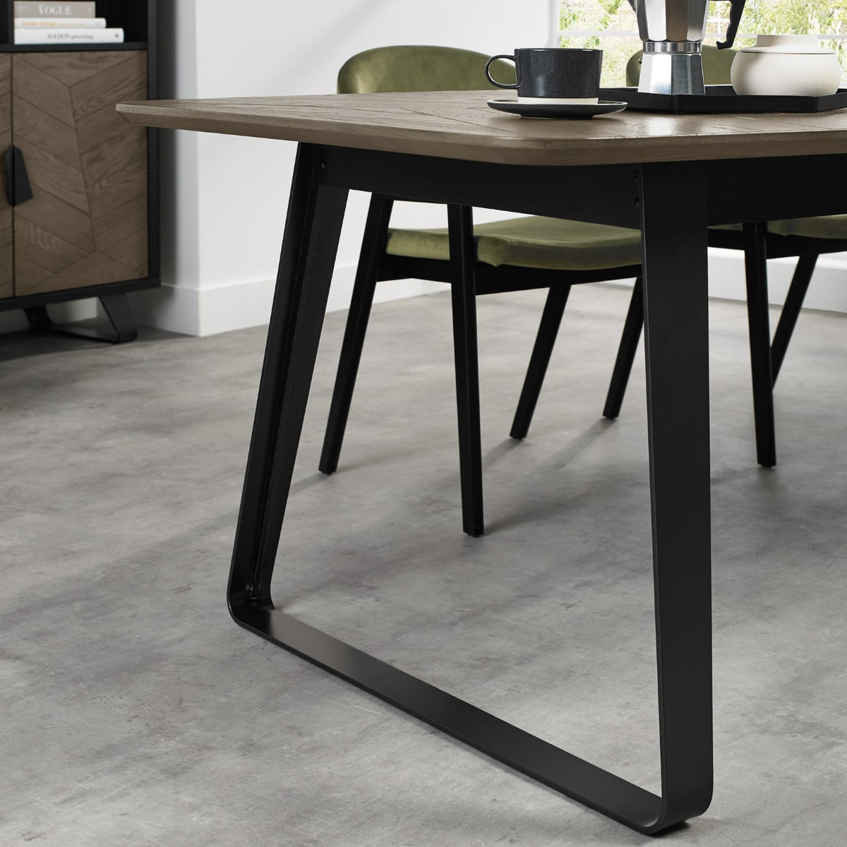 Weathered oak extending dining table with black metal base, designed by Bentley Designs, showing the table's rustic finish and extendable features.
