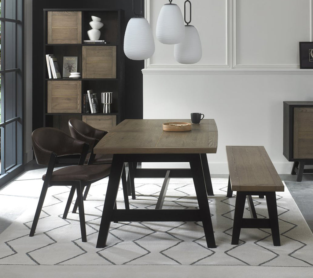 Weathered oak dining table set with two brown chairs and a small bench by Bentley Designs, showing the rustic table and seating.