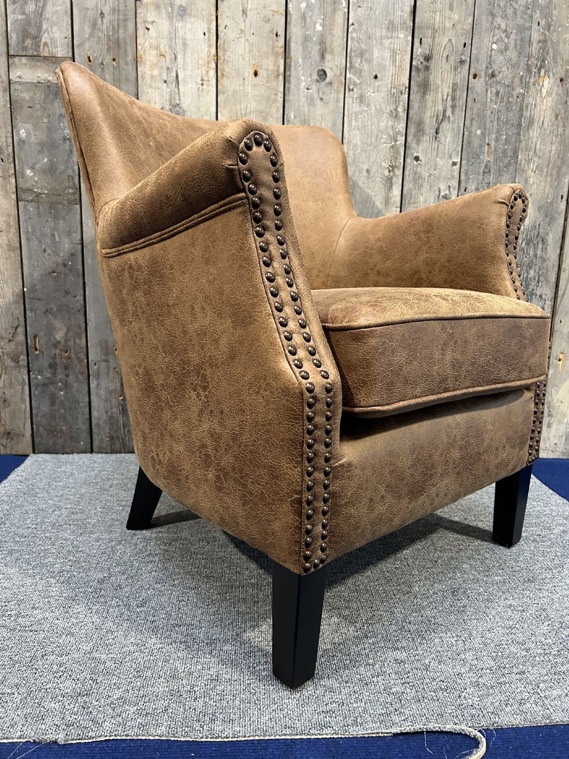 Vintage Style Brown Leather Lounge Armchair with Stud Detailing and Curved Back - Home Furniture Interiors