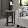 Silver grey wooden round side table with black metal base, ideal for living room or bedroom as a stylish end table.