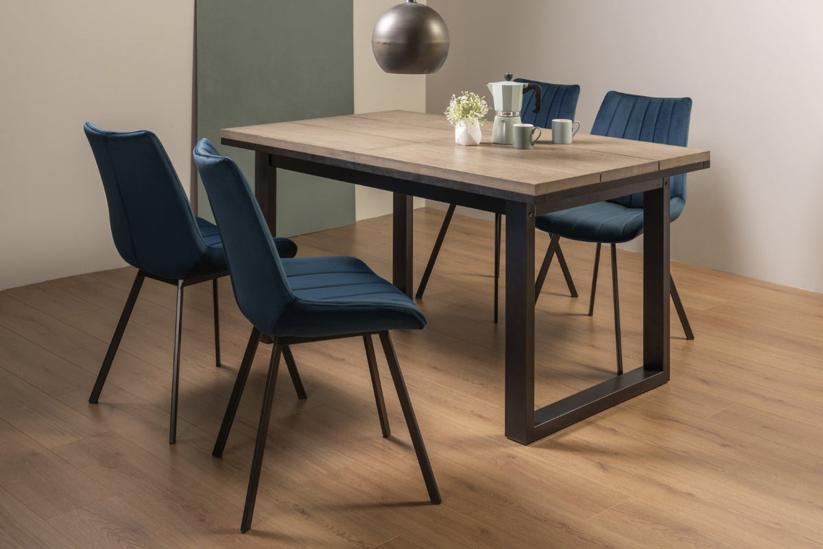 Weathered Oak extending dining table with four blue velvet Bentley Designs chairs, modern table and chair set for dining room.