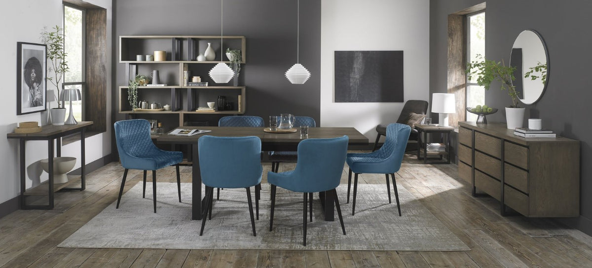 Weathered Oak extending dining table with six blue velvet Bentley Designs chairs in a stylish table and chair set.