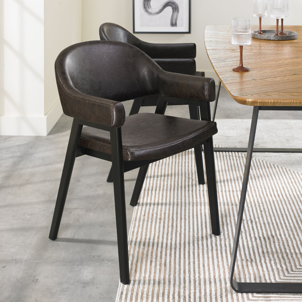 Vintage brown leather Bentley Designs dining arm chair with black metal legs, showcasing a classic, elegant design.