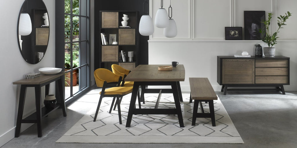 Weathered oak dining set by Bentley Designs with a table, two side chairs, and a bench, showcasing a rustic wood finish.
