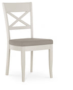 Washed oak extending dining table with four grey leather chairs from Bentley Designs, showcasing a modern dining set.