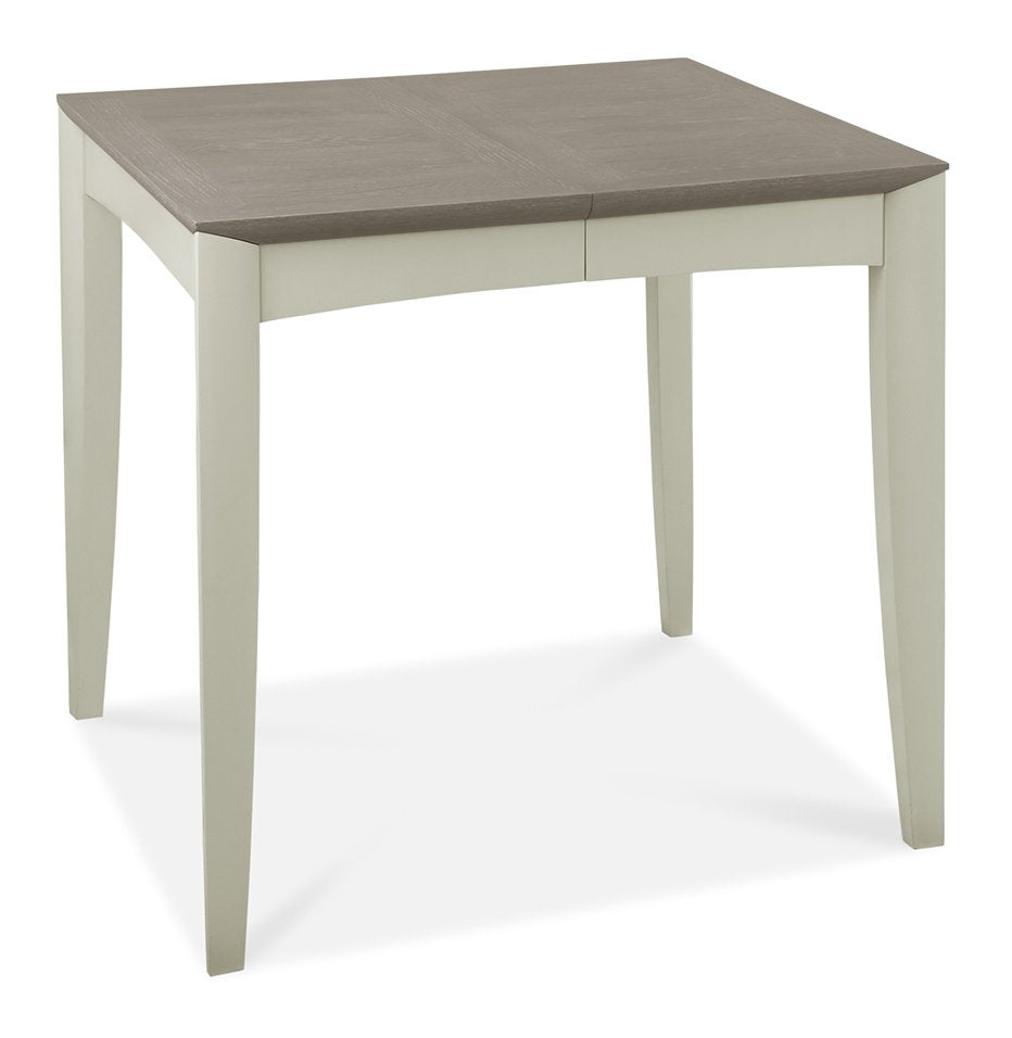Bentley Designs washed oak dining table set with four grey fabric chairs, showcasing a modern, rustic table and comfortable seating.