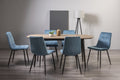 Weathered oak dining table set with six blue velvet chairs by Bentley Designs, showcasing a stylish and elegant dining room setup.