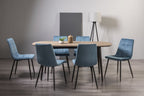 Weathered oak dining table set with six blue velvet chairs by Bentley Designs, showcasing a stylish and elegant dining room setup.