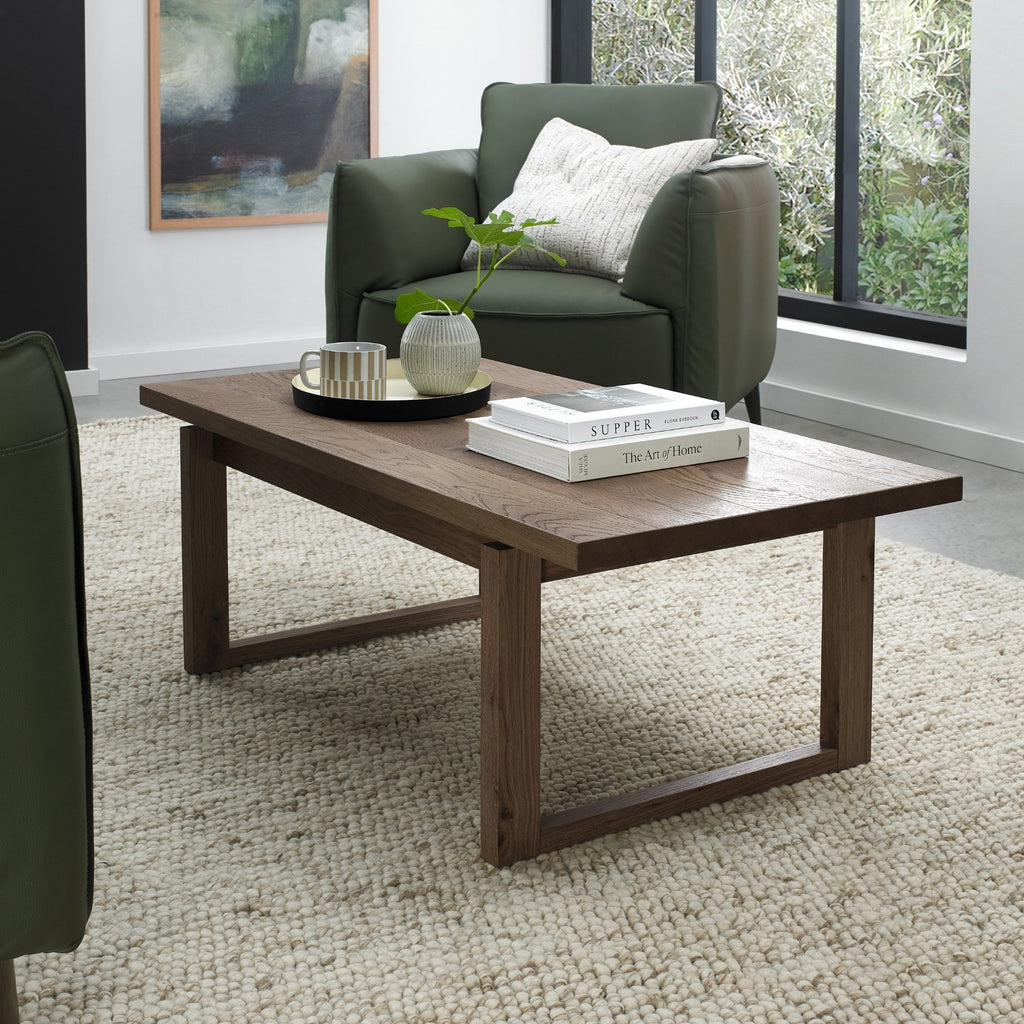 Dark oak Bentley Designs coffee table with wire brushed finish, featuring a sleek, modern wooden surface and sturdy legs.