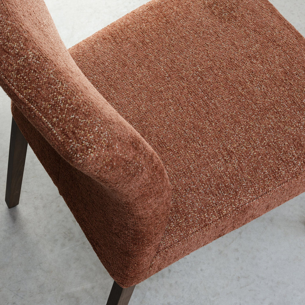 Pair of Auburn Brown Bentley Designs fabric dining chairs with dark oak legs, showcasing plush upholstery and sleek wooden legs.