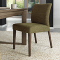 Pair of green fabric dining chairs with dark oak legs from Bentley Designs, showing the upholstered seats and sleek wooden legs.
