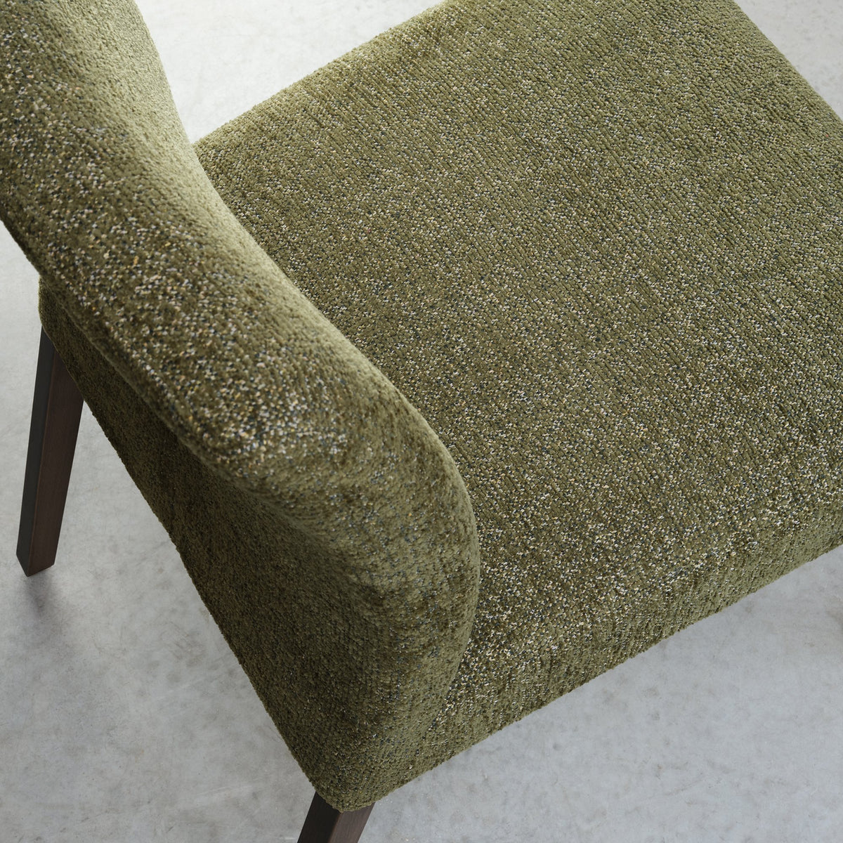 Pair of green fabric dining chairs with dark oak legs by Bentley Designs, showing the upholstered seats and wooden frames.