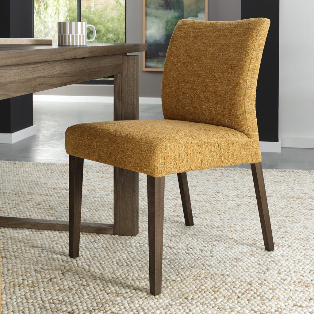 Pair of mustard yellow fabric dining chairs with dark oak legs by Bentley Designs, showcasing comfortable padded seats and stylish design.