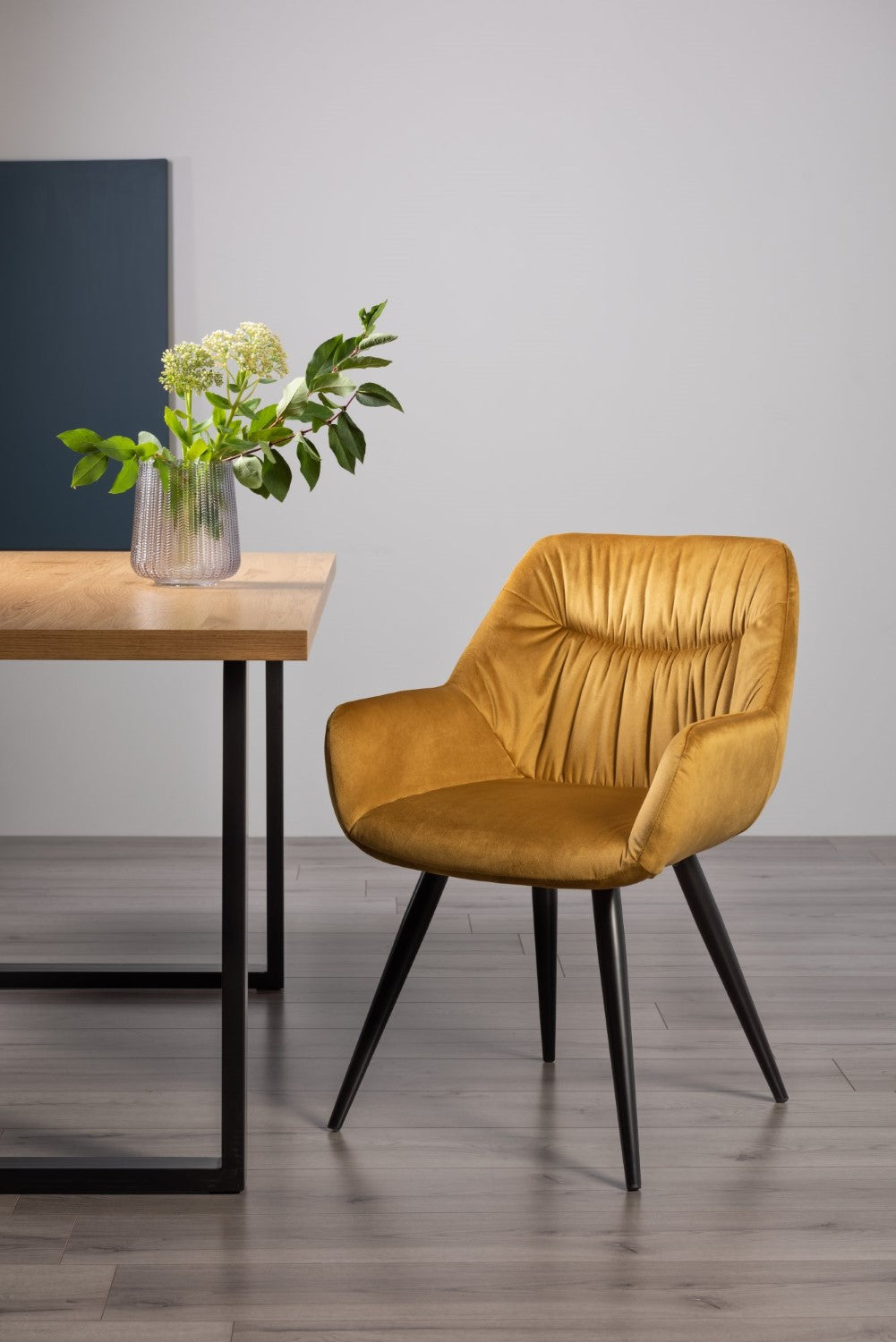 Yellow velvet Bentley Designs dining arm chair with pleated back and pattern, showcasing plush fabric and elegant design.