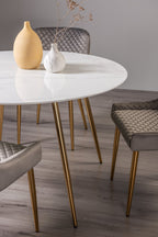 White marble glass round dining table with gold legs by Bentley Designs, perfect for modern dining spaces.