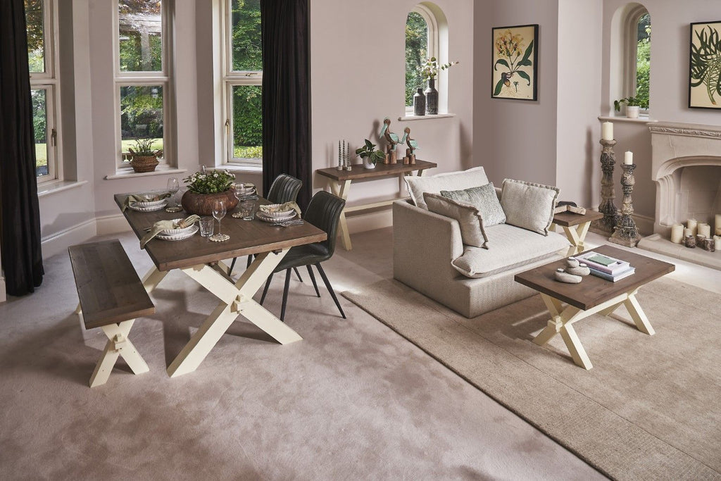 Living room with a wooden dining table and chairs, sofa, and decorative elements.