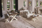 Living room with a wooden dining table and chairs, sofa, and decorative elements.