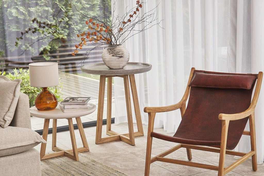 Modern living room with a brown leather chair, side table, and lamp.